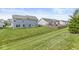 Grassy backyard featuring a level lawn, neighboring houses, and a wooden fence at , Brownsburg, IN 46112