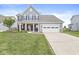 Beautiful two-story home with a lush green lawn, a long driveway, and classic architectural details at , Brownsburg, IN 46112