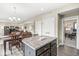 Kitchen island adjacent to the dining room with wood flooring and overhead lighting at , Brownsburg, IN 46112