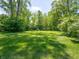 Large grassy back yard surrounded by mature trees and green foliage at 10307 Wilson Rd, Brownsburg, IN 46112