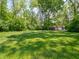 Spacious back yard with green grass and a storage shed surrounded by mature trees at 10307 Wilson Rd, Brownsburg, IN 46112