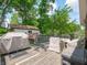 Backyard featuring a wooden deck with seating, grills, and a detached garage offering ample space for outdoor activities at 10307 Wilson Rd, Brownsburg, IN 46112