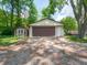 Exterior view of a spacious two-car garage with additional storage sheds, providing ample parking and storage space at 10307 Wilson Rd, Brownsburg, IN 46112