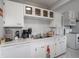 Bright white kitchen with modern countertops, appliances, and marble look flooring at 10307 Wilson Rd, Brownsburg, IN 46112