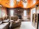 Inviting living room featuring brick fireplace, wood ceilings and comfortable armchair at 10307 Wilson Rd, Brownsburg, IN 46112