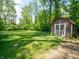 Backyard shed featuring white trim on well-manicured lawn surrounded by mature trees, offering ample storage space at 10307 Wilson Rd, Brownsburg, IN 46112