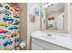 This charming bathroom features a single sink, mirror, and a playful truck-themed shower curtain at 110 Avon Ln, Noblesville, IN 46062