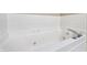 Close up of a jetted bathtub with white tile and crystal handles and jets at 110 Avon Ln, Noblesville, IN 46062