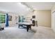 A bonus room features an air hockey table, carpet, vaulted ceilings, and large windows at 110 Avon Ln, Noblesville, IN 46062
