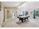 A bright bonus room with a high ceiling has an air hockey table, white trim and plenty of windows at 110 Avon Ln, Noblesville, IN 46062