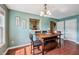 Dining room with a wooden dining table, pendant lighting, wood floors, and a pass-through to the kitchen at 110 Avon Ln, Noblesville, IN 46062