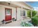 Inviting front porch with decorative plants, a bench, and a red front door, creating a warm welcome at 110 Avon Ln, Noblesville, IN 46062