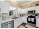 Bright kitchen with white cabinets, stainless steel appliances, and a convenient pass-through to the dining area at 110 Avon Ln, Noblesville, IN 46062