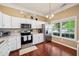 Kitchen featuring white cabinets, stainless steel appliances, and a large window for natural light at 110 Avon Ln, Noblesville, IN 46062