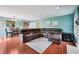 Open-concept living room with hardwood floors, a large sectional, and connection to the kitchen, ideal for gatherings at 110 Avon Ln, Noblesville, IN 46062