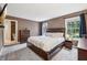 A traditional main bedroom suite features a dark wood bed frame, neutral carpet and a door to the en suite bathroom at 110 Avon Ln, Noblesville, IN 46062