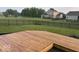 Wooden deck in a backyard with a black fence, lush green grass, and neighborhood views at 1287 Highland Lake Way, Brownsburg, IN 46112