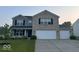 Charming two-story home featuring a three car garage, brick and siding facade, and well-manicured lawn at 1287 Highland Lake Way, Brownsburg, IN 46112