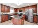 Well-equipped kitchen featuring dark wood cabinets, stainless steel appliances, and a central island at 1287 Highland Lake Way, Brownsburg, IN 46112
