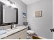 This powder room features granite countertops, stylish fixtures, and wood flooring at 12961 Limberlost Dr, Carmel, IN 46033