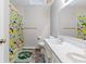 A brightly lit bathroom featuring a vanity with dual sinks and colorful shower curtain at 12961 Limberlost Dr, Carmel, IN 46033
