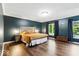Serene bedroom with hardwood floors, a king-size bed, and large windows for natural light at 12961 Limberlost Dr, Carmel, IN 46033