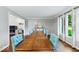 Spacious dining room with a long wooden table, tufted chairs, and windows offering natural light at 12961 Limberlost Dr, Carmel, IN 46033