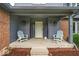 Inviting front porch with charming decor, including Adirondack chairs and stylish lighting fixtures at 12961 Limberlost Dr, Carmel, IN 46033