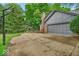 Attached two-car garage alongside a driveway and basketball hoop, surrounded by mature trees at 12961 Limberlost Dr, Carmel, IN 46033