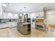 Spacious eat-in kitchen with white cabinets, granite counters, center island, desk space, and stainless appliances at 12961 Limberlost Dr, Carmel, IN 46033