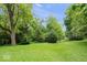 Spacious backyard with green lawn and mature trees at 13297 Highland Springs Dr, McCordsville, IN 46055