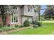 View of the home's entrance, showcasing brickwork, siding, manicured bushes, and a small fenced garden area at 13297 Highland Springs Dr, McCordsville, IN 46055
