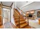 Inviting foyer features a staircase with wood trim, hardwood floors, and a view into the living room at 13297 Highland Springs Dr, McCordsville, IN 46055