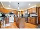 Kitchen with wood cabinets, granite countertops, and stainless steel refrigerator at 13297 Highland Springs Dr, McCordsville, IN 46055