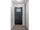 Stylish black front door with a decorative glass insert, complemented by modern trim and hardwood floors at 1408 Snead Cir, Avon, IN 46123