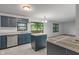 Well-lit kitchen featuring dark blue cabinets, a view to the backyard, and stainless steel appliances at 1408 Snead Cir, Avon, IN 46123