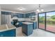 Bright kitchen with blue cabinetry, stainless steel appliances, a tiled island, and a sliding glass door to the deck at 1408 Snead Cir, Avon, IN 46123