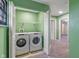 Functional laundry room in green with modern appliances, shelving and an easy access to the hallway at 1408 Snead Cir, Avon, IN 46123