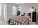 A cozy bedroom with a plaid comforter, locker-style bedside tables, and windows offering natural light at 15219 Farrington Way, Fishers, IN 46037