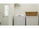 Bright laundry room featuring stacked washer and dryer with a basket on top and shelf with storage containers at 15363 Alperton Rd, Fishers, IN 46037
