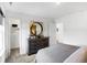 Bright bedroom featuring neutral carpet, a wooden dresser, a round mirror, and an open closet at 15387 Alperton Rd, Fishers, IN 46037