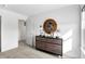 Cozy bedroom featuring neutral carpet, a wooden dresser, round mirror, and a view of another room at 15387 Alperton Rd, Fishers, IN 46037