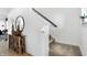 Entryway with hardwood floors, console table, decorative mirror, and a staircase with carpeted steps at 15387 Alperton Rd, Fishers, IN 46037