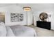 Well-lit main bedroom boasts modern art, an elegant dresser, and an open layout to the en suite at 15387 Alperton Rd, Fishers, IN 46037