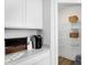 Organized pantry with white shelving and ample storage space, alongside a kitchen counter with modern appliances at 15387 Alperton Rd, Fishers, IN 46037