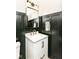 Chic powder room showcasing black wainscoting, a modern white vanity and a gold framed mirror at 1620 W New York St, Indianapolis, IN 46222