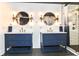Modern bathroom featuring dual vanities, unique mirrors, and walk-in shower with subway tiles at 1620 W New York St, Indianapolis, IN 46222