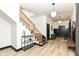 Bright foyer featuring hardwood floors, wooden staircase, and modern light fixtures at 1620 W New York St, Indianapolis, IN 46222