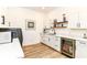 Bright laundry room with white cabinets, sleek hardware, quartz countertops and a beverage fridge at 1620 W New York St, Indianapolis, IN 46222