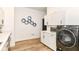 Clean laundry room with white cabinets, quartz countertops and a front loading washing machine and dryer at 1620 W New York St, Indianapolis, IN 46222
